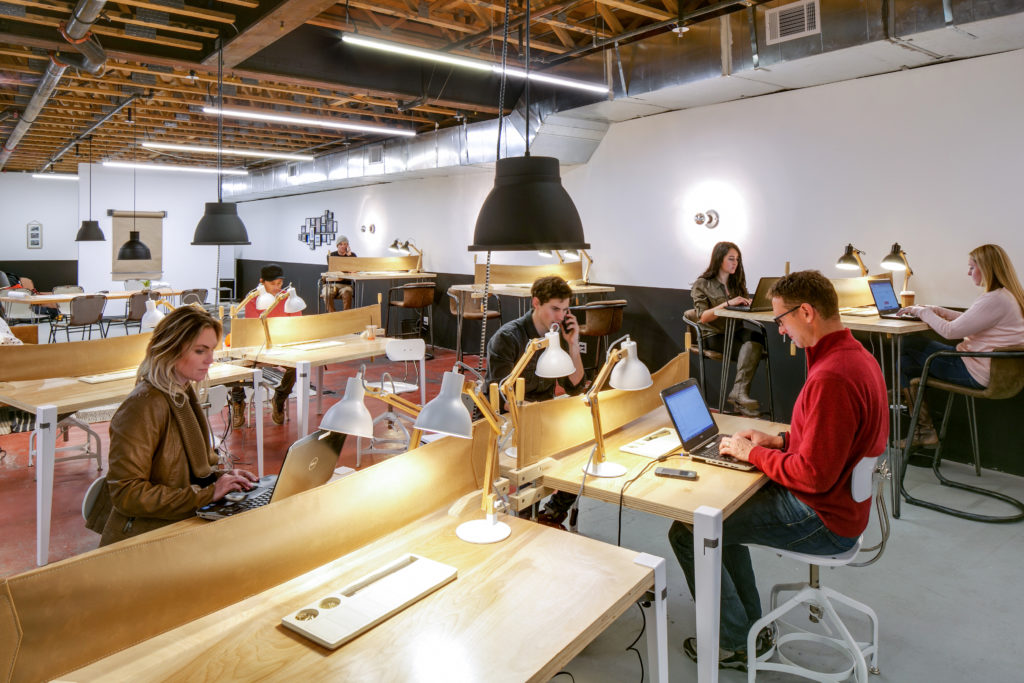 Coworkers working at personal and group desks at The Fort